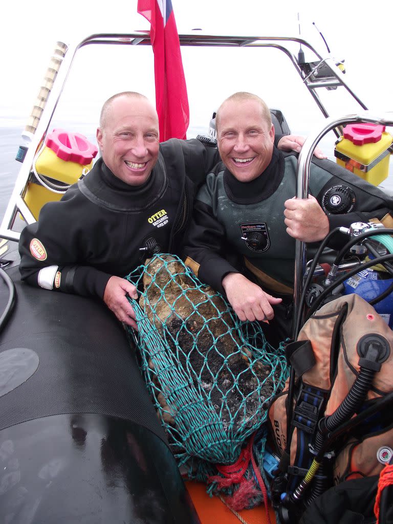 En esta foto sin fecha proporcionada por Norfolk Historic Shipwrecks, Julian y Lincoln Barnwell posan para una foto con la campana del HMS Gloucester, encontrada en 2007. Excavadores e historiadores le cuentan al mundo sobre el naufragio de un buque de guerra real que se hundió en 1682 mientras transportaba el futuro rey James Stuart. El HMS Gloucester encalló mientras navegaba por bancos de arena frente a la ciudad de Great Yarmouth, en la costa este de Inglaterra. Los restos del Gloucester fueron encontrados en 2007 por los hermanos Julian y Lincoln Barnwell y otros después de una búsqueda de cuatro años. (Norfolk Historic Shipwrecks via AP)