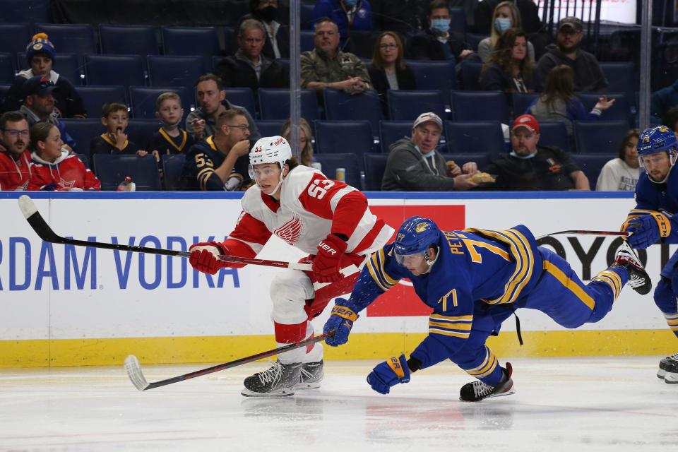 Sabres right wing John-Jason Peterka falls while battling for the puck with Red Wings defenseman Moritz Seider during the second period of the preseason game in Buffalo, N.Y., Saturday, Oct. 9, 2021.