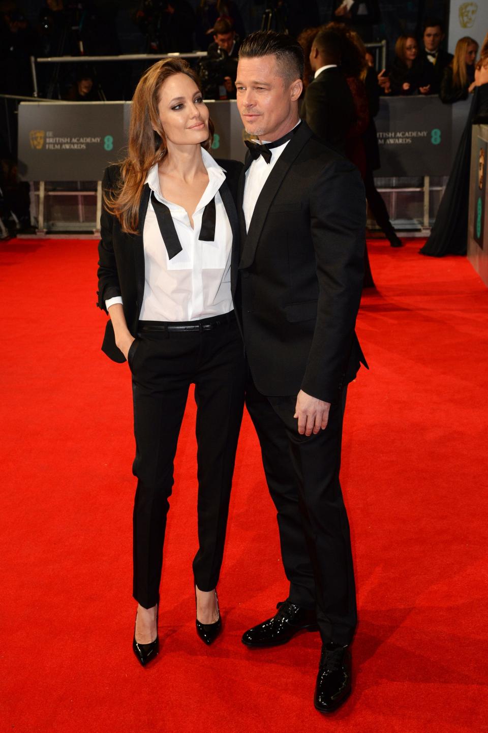 Brad Pitt and Angelina Jolie wearing matching suits.