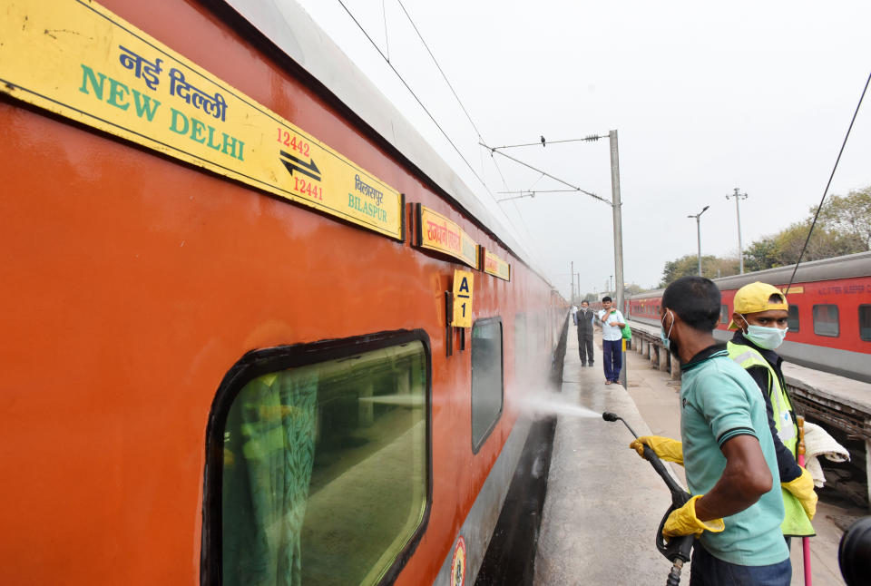 Railway cleaning staff chemically disinfect and sanitize a Rajdhani train as a precautionary measure in view of coronavirus concerns in New Delhi.