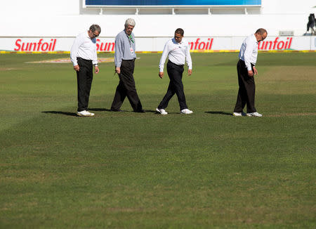 The umpires and ground staff inspect the playing surface after heavy overnight rain on the third day of the first cricket test match between South Africa and New Zealand in Durban, South Africa, August 21, 2016. REUTERS/Rogan Ward