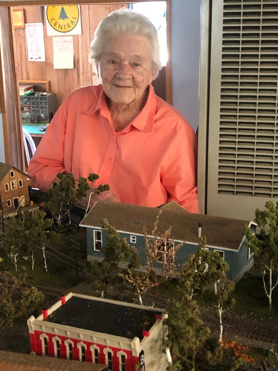 Helen Beal (Jonesport, Maine), designed, built and operated the Maine Central Model Railroad with husband Harold “Buz” Beal for the past four decades. Helen is standing in front of a model her husband made of their own Jonesport home (green).
