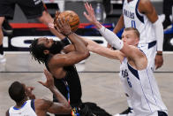 Brooklyn Nets guard James Harden, center left, shoots against Dallas Mavericks center Kristaps Porzingis (6) during the second half of an NBA basketball game Saturday, Feb. 27, 2021, in New York. (AP Photo/John Minchillo)