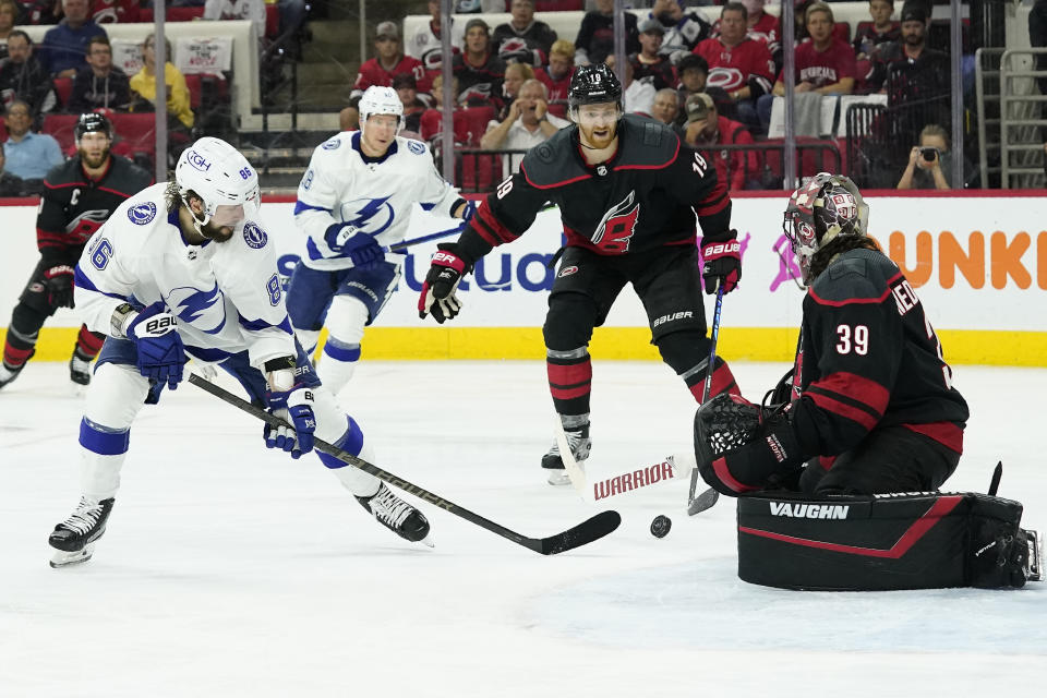 Tampa Bay Lightning right wing Nikita Kucherov (86) tries to score against Carolina Hurricanes goaltender Alex Nedeljkovic (39) while defenseman Dougie Hamilton (19) looks on during the third period in Game 5 of an NHL hockey Stanley Cup second-round playoff series in Raleigh, N.C., Tuesday, June 8, 2021. (AP Photo/Gerry Broome)