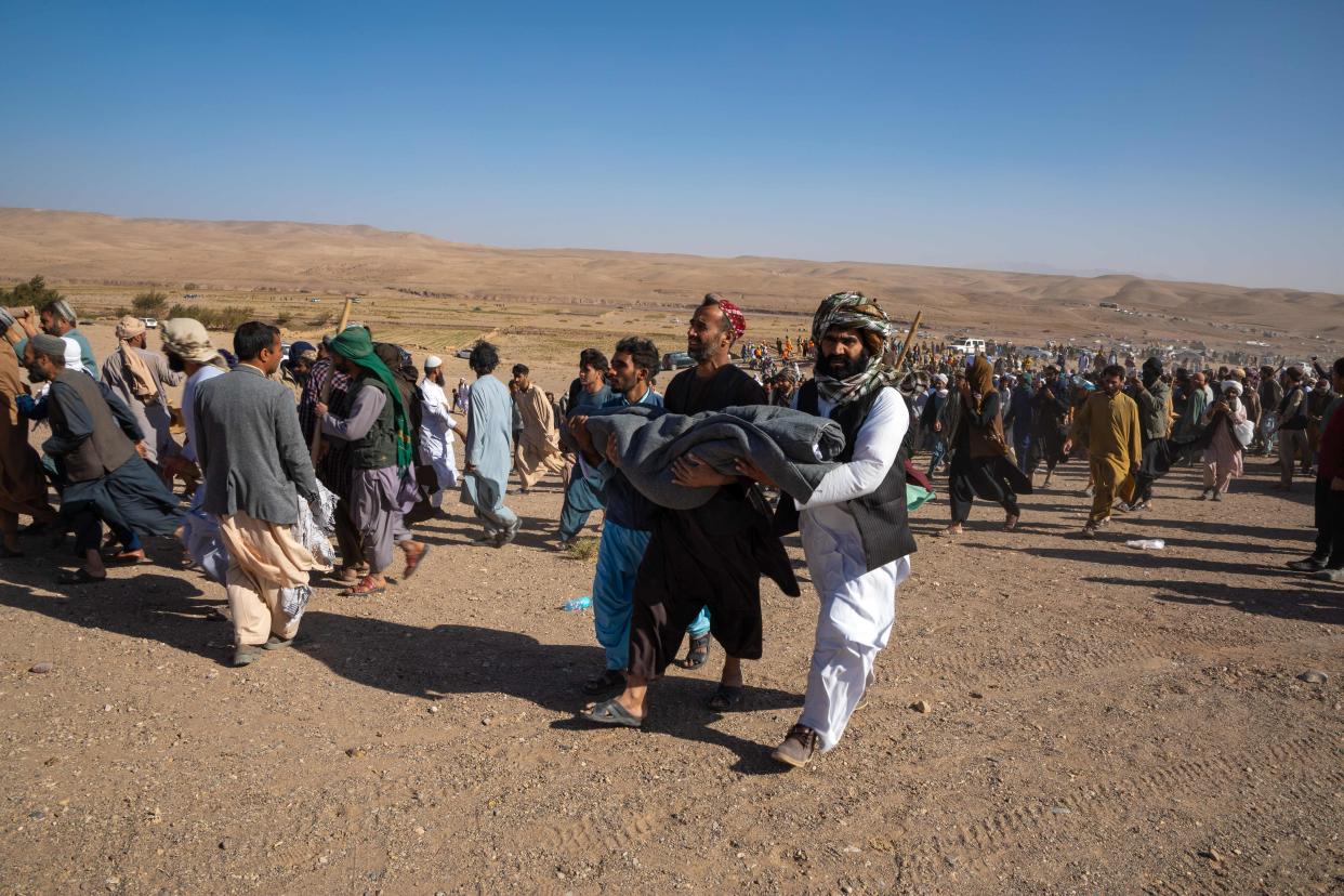 People carry bodies of those killed in the earthquake.