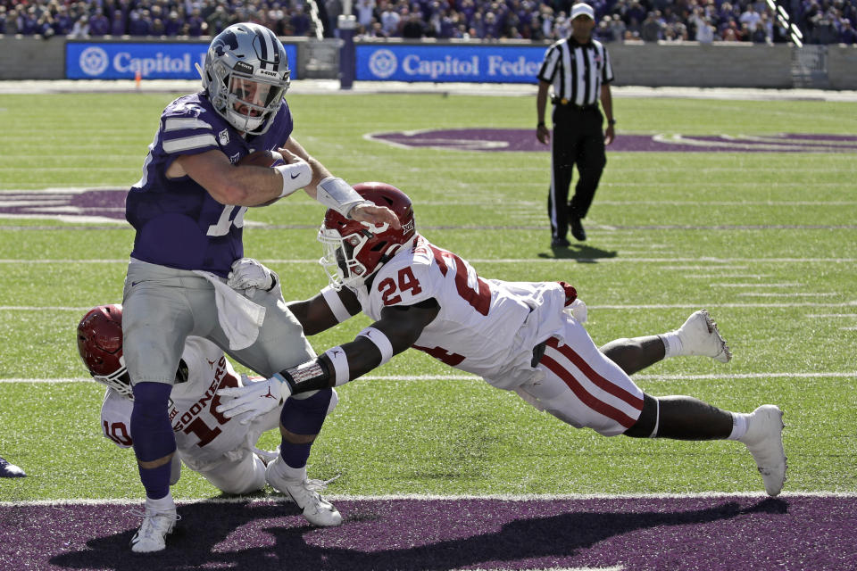 FILE - In this Oct. 26, 2019, file photo, Kansas State quarterback Skylar Thompson (10) runs into the end zone to score a touchdown as Oklahoma linebacker Brian Asamoah (24) and safety Pat Fields (10) defend during the second half of an NCAA college football game in Manhattan, Kan. Kansas State won 48-41. Thompson is now set to make his 29th career start when the Wildcats try to only their fifth win ever over a top-five team, this week against Oklahoma. This matchup will be in Norman. (AP Photo/Charlie Riedel, File)