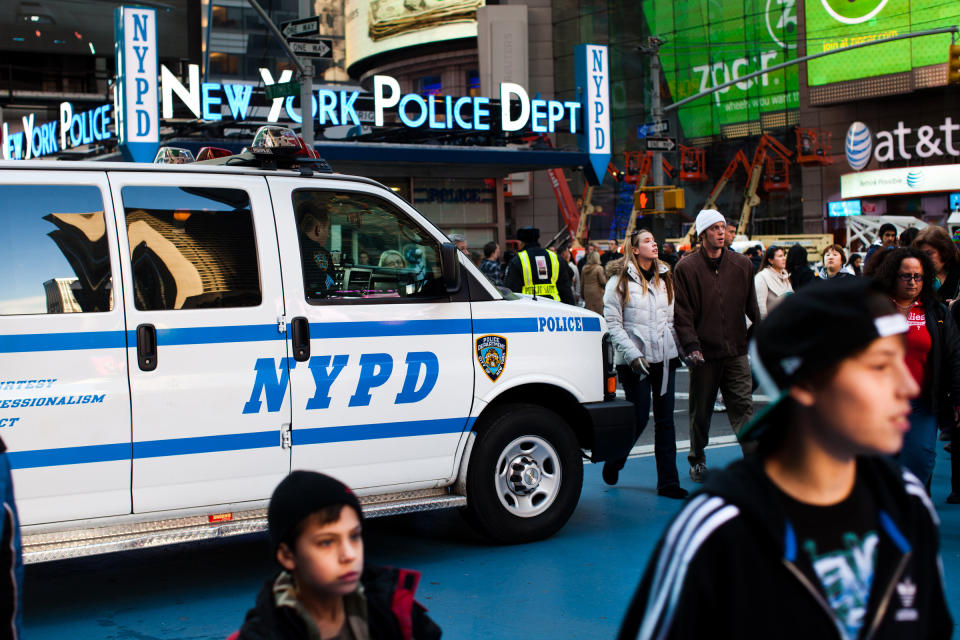 FILE - In this Dec. 31, 2011 file photo, pedestrians pass police vans in New York City’s Times Square as city police officials begin ramping up security before New Year’s Eve celebrations. The New York City police use an array of security measures for the event that turns the "Crossroads of the World" into a massive street party in the heart of Manhattan. (AP Photo/John Minchillo, File)