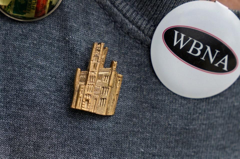 Kari Lang wears a gold pin depicting the Cranston Street Armory, which the West Broadway Neighborhood Association sold to generate support for the historic building's redevelopment.