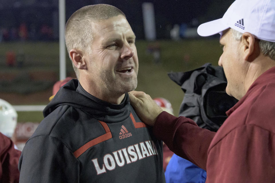 Louisiana-Lafayette head coach Billy Napier is congratulated by Louisiana-Monroe Offensive Coordinator Rich Rodriguez after Louisiana-Lafayette won 21-16 in an NCAA college football game in Lafayette, La., Saturday, Nov. 27, 2021. (AP Photo/Matthew Hinton)