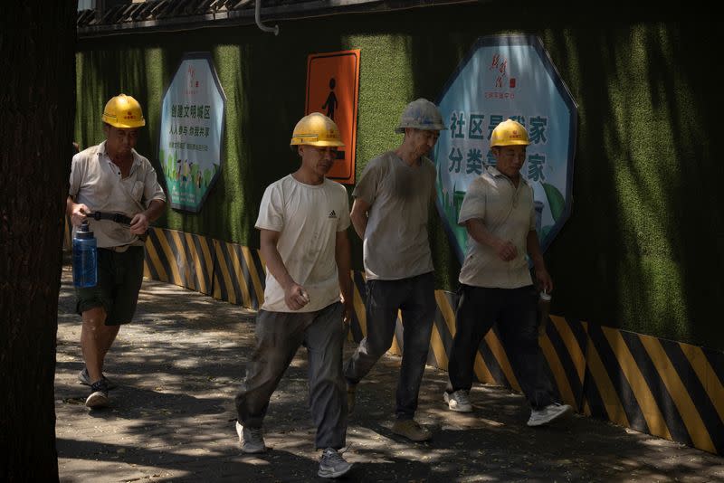 Workers walk in a street in Beijing