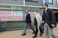 People walk by an electronic stock board of a securities firm in Tokyo, Monday, March 1, 2021. Asian shares were higher on Monday on hopes for President Joe Biden’s stimulus package and bargain-hunting buying after the shares’ fall last week. (AP Photo/Koji Sasahara)