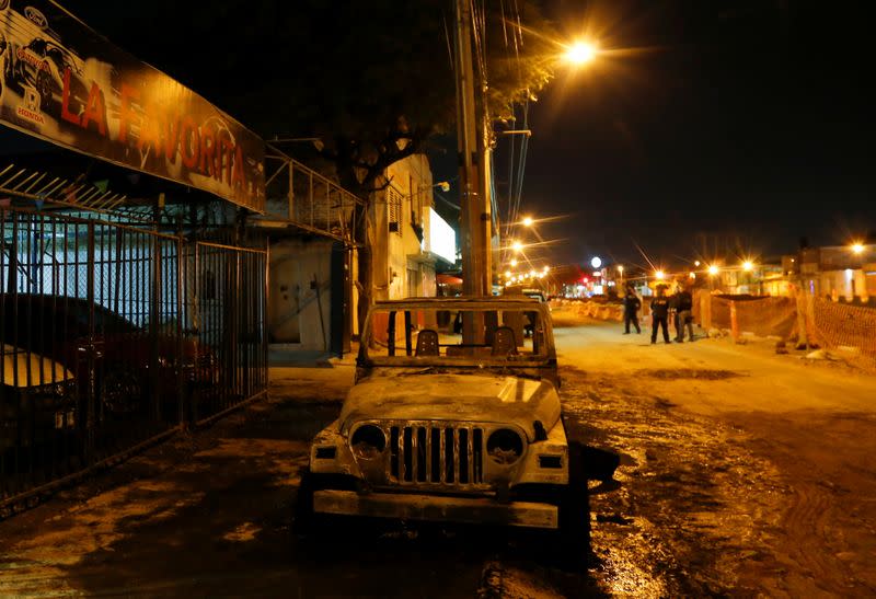 The wreckage of a car that was burnt by unknown assailants is pictured after an attack to a car dealership in Celaya