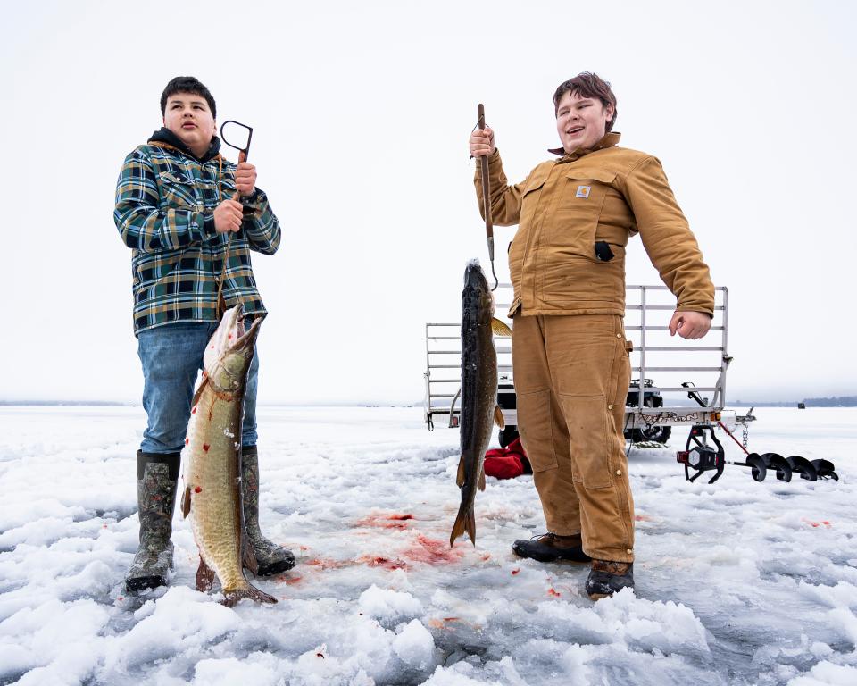 Ganebik Johnson (left), 13, and Zack Randall, 15, hold up the muskies they spearfished during the Ishpaagoonika Deep Snow Camp at Pelican Lake on Jan. 27, 2024.