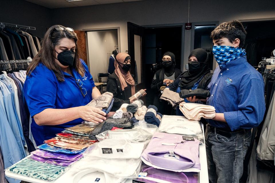 Kim Collins, left, executive aide in the Middle Tennessee State University Career Development Center, left, collects Muslim clothing items solicited by the Alnassari family — daughters, Zaynab and Fatima, mom Khadijah and son Ahmed. The triplets, 14, are dual enrollment freshmen, and biology majors pursuing a premed pathway.