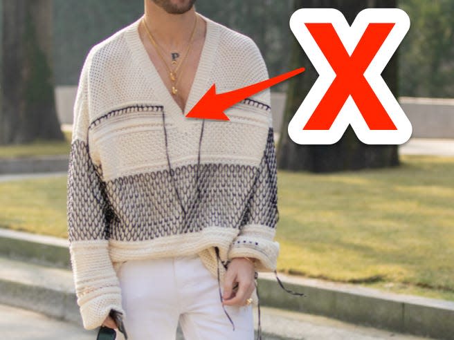 red x and arrow pointing at deep v cream sweater someone is wearing on the street