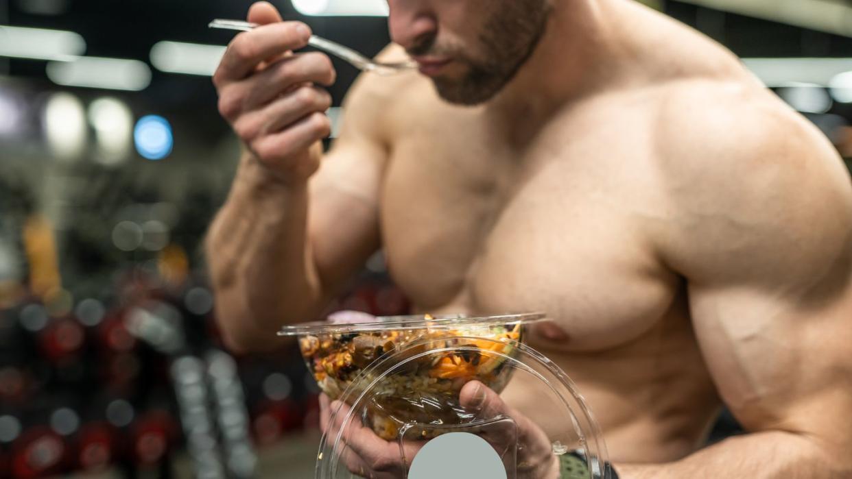 powerful athletic man with great physique eating a healthy salad mockup your brand