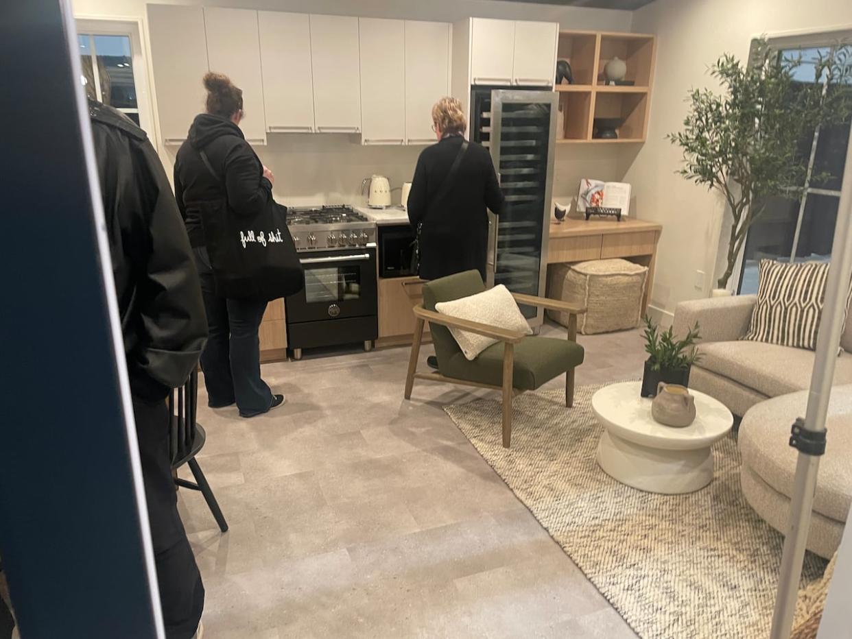 Visitors check out the interior of the national home show's feature garden suite. The pre-fab build is 570-square-feet and priced at $210,000. (Ethan Lang/CBC - image credit)