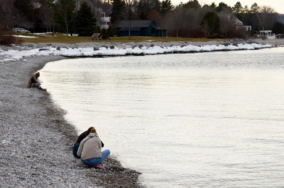 People take advantage of the warm weather on Thursday, Feb. 8, 2024 to hunt for Petoskey stones near the breakwater in Petoskey.
