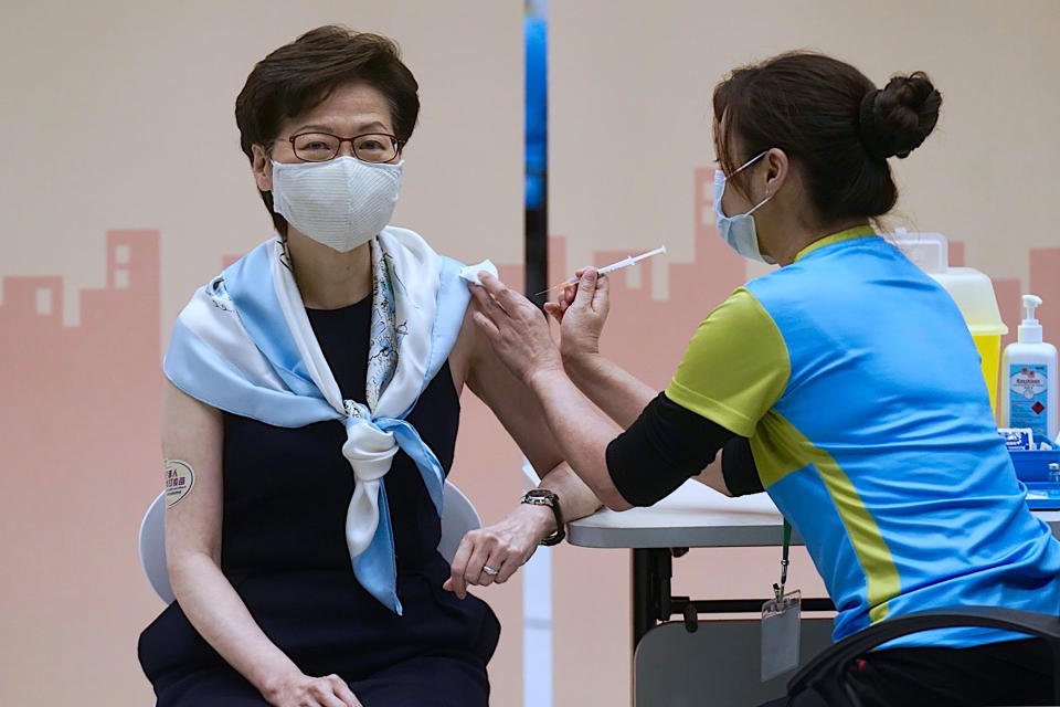 FILE- In this Monday, March. 22, 2021, file photo, Hong Kong Chief Executive Carrie Lam receives the second dose of the Sinovac Biotech COVID-19 vaccine at a Central Government office in Hong Kong. Hong Kong's sudden suspension of a COVID-19 vaccine developed by Pfizer and BioNTech is another blow to a vaccination program already struggling against a wall of public distrust. Hong Kong on Wednesday, March 24, 2021, suspended use of the Pfizer vaccine, distributed by Chinese pharmaceutical firm Fosun Pharma, after defective packaging such as loose vial lids and cracks on bottles were found in one of two batches of the vaccine. (AP Photo/Vincent Yu, File)