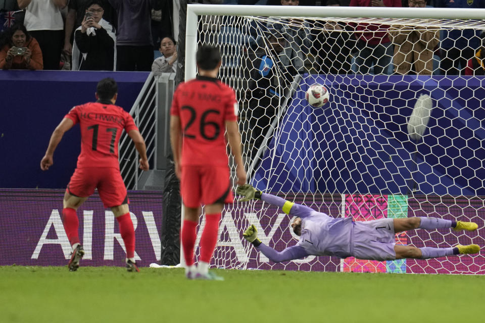 South Korea's Hwang Hee-chan, left, scores his side's first goal past Australia's goalkeeper Mathew Ryan during the Asian Cup quarterfinal soccer match between Australia and South Korea at Al Janoub Stadium in Al Wakrah, Qatar, Friday, Feb. 2, 2024. (AP Photo/Aijaz Rahi)