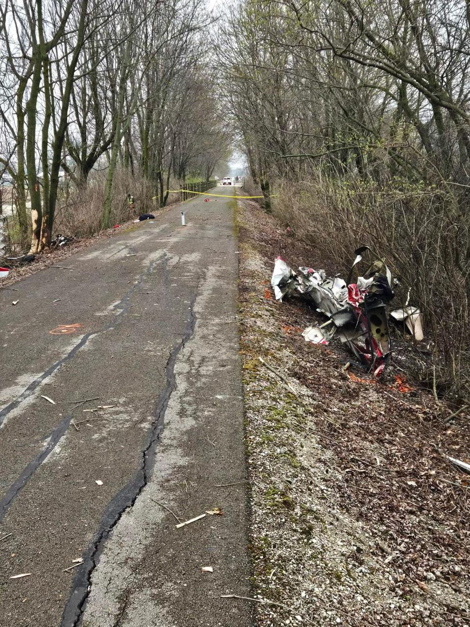 A portion of a small plane that crashed on Monday morning is visible along the Cardinal Greenway north of Riggin Road. The crash injured the pilot and two pedestrians who were walking on the greenway at the time of the crash.