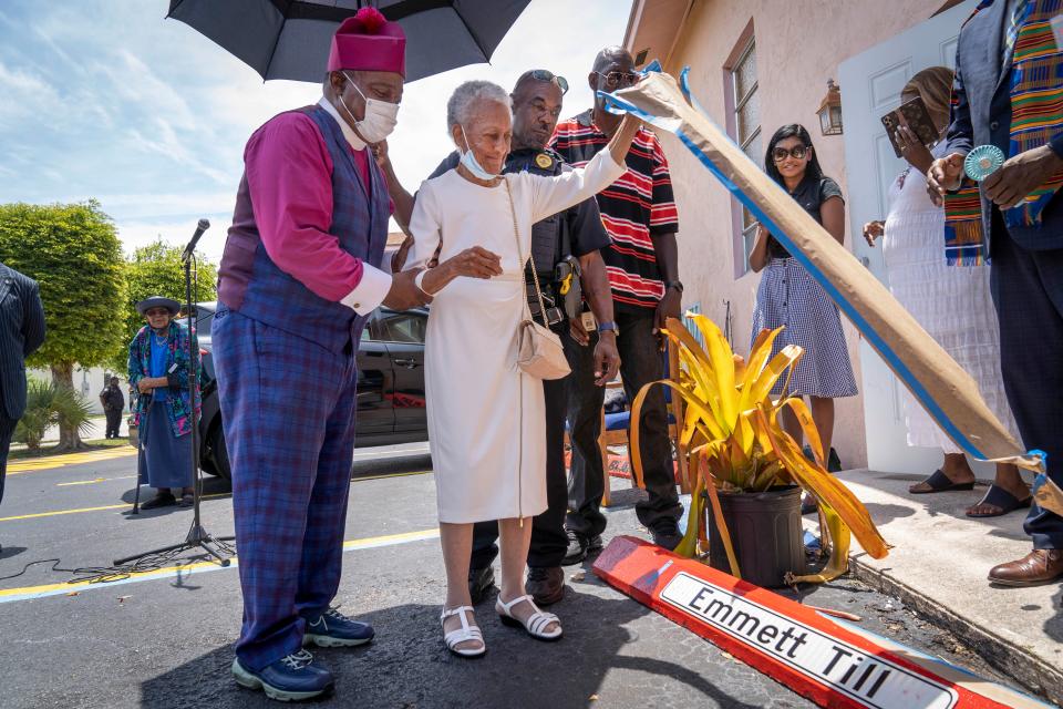 Bishop Thomas Masters, left, and police Sgt. Roosevelt Lee help Thelma Wright Edwards, the oldest living close relative of Emmett Till unveil a memorial in the parking lot New Macedonia Missionary Baptist Church in Riviera Beach, Florida on June 19, 2022