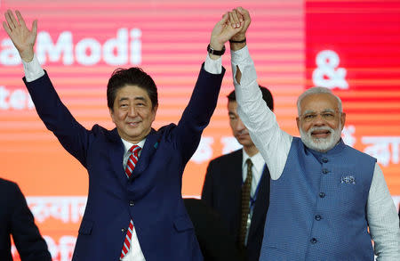 Japanese Prime Minister Shinzo Abe (L) and his Indian counterpart Narendra Modi raise hands after the groundbreaking ceremony for a high-speed rail project in Ahmedabad, India, September 14, 2017. REUTERS/Amit Dave