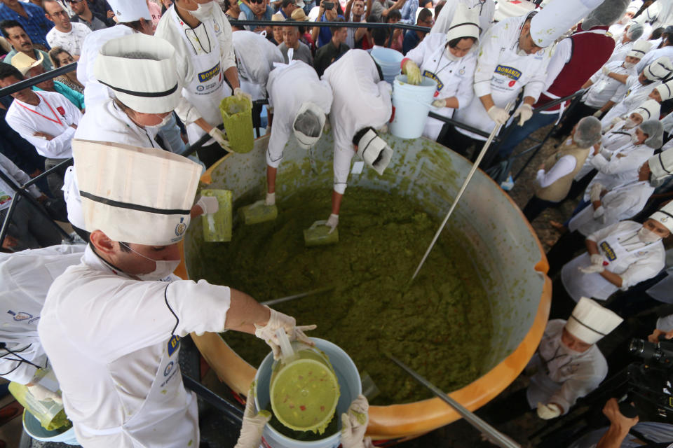 <p>Freiwillige einer Kochschule haben Großes vor: In Mexiko wollen sie die größte Menge Guacamole verteilen, die je ausgeschenkt wurde. Deswegen stampfen und mischen sie vor den Augen der Guiness-Buch-Kontrolleure Avocados. (Bild: Reuters) </p>