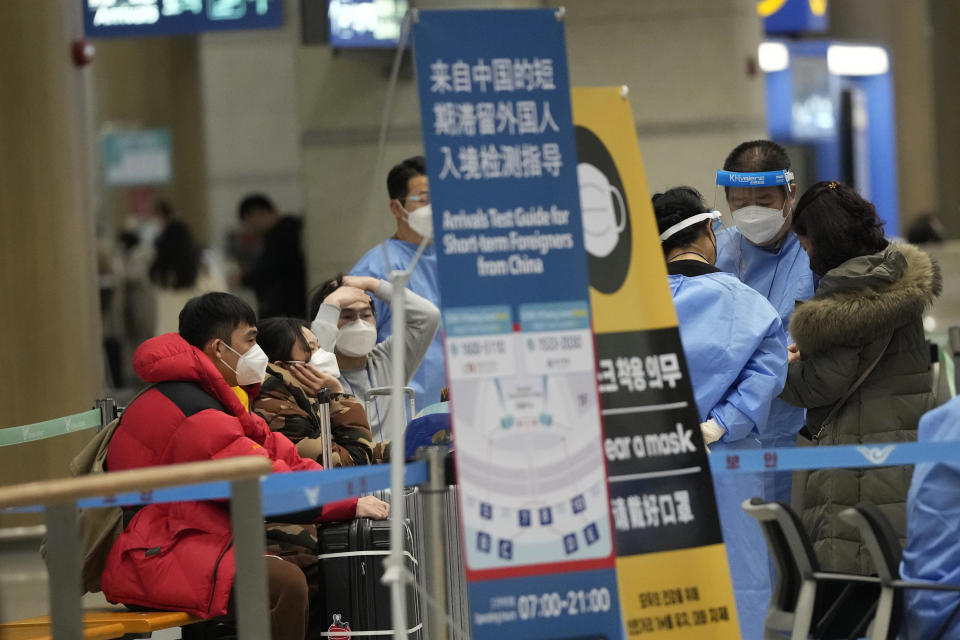 Passengers coming from China wait before proceeding to a COVID-19 testing center upon their arrival at the Incheon International Airport in Incheon, South Korea, on Jan. 14, 2023. South Korea says it will continue to restrict the entry of short-term travelers from China through the end of February over concerns that the spread of COVID-19 in that country may worsen following the Lunar New Year’s holidays. (AP Photo/Ahn Young-joon)