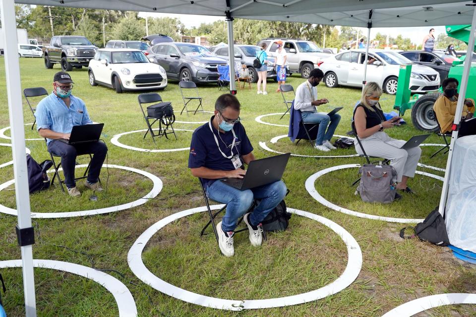 Members of the media are social distanced from one another as they report on a rally as former President Barack Obama speaks to a crowd while campaigning for his former vice president, Democratic nominee Joe Biden, on Oct. 27, 2020, in Orlando, Florida.