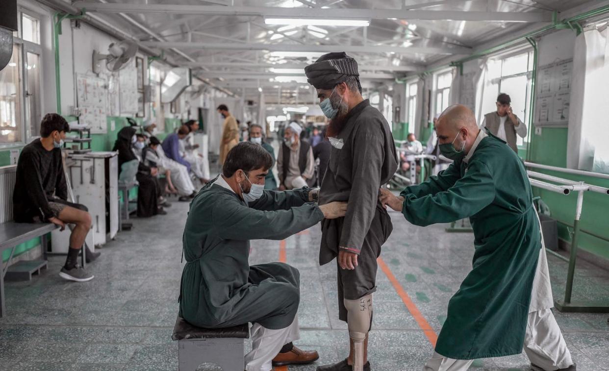 <span class="caption">International Committee of the Red Cross rehabilitation center staff members assist a Taliban member on Oct. 11, 2021, in Kabul, Afghanistan.</span> <span class="attribution"><a class="link " href="https://www.gettyimages.com/detail/news-photo/members-of-international-committee-of-red-cross-news-photo/1235821036" rel="nofollow noopener" target="_blank" data-ylk="slk:Bulent Kilic/AFP via Getty Images;elm:context_link;itc:0;sec:content-canvas">Bulent Kilic/AFP via Getty Images</a></span>