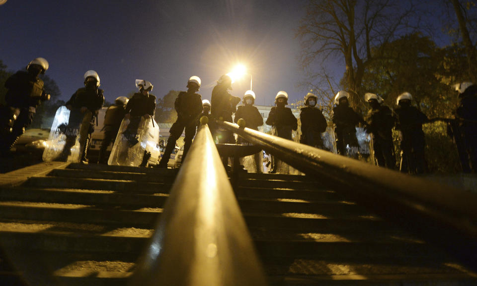 Police stand guard while protesters block the parliament in Warsaw, Poland, Wednesday Oct. 28, 2020. People across Poland stayed off their jobs and huge crowds poured onto the streets for a seventh straight day of protests Wednesday, enraged over a top court ruling that bans abortions in cases of fetal abnormalities. (AP Photo/Czarek Sokolowski)