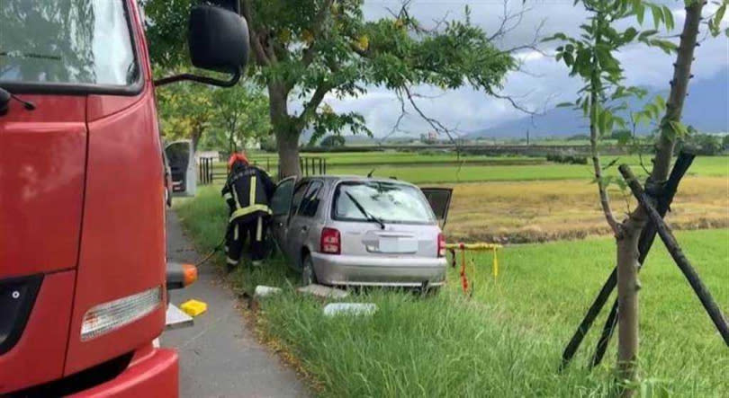 64歲吳姓婦人駕車撞路樹，車頭變形，警方消防人員到場救援。（圖／中國時報王志偉翻攝）