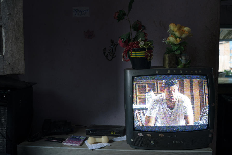 In this Nov. 28, 2019 photo, an old television transmits a Brazilian soap opera in the home of Domingas Rufina, who is a member of a local women's association in Trairao, Para state, Brazil. The 67-year-old is considering moving to another quiet town after a leader of her association was threatened after denouncing illegal logging in the nearby Trairao national forest. (AP Photo/Leo Correa)