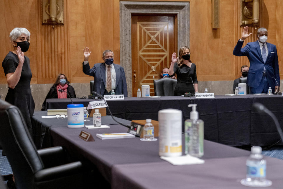 From left, Kiran Ahuja, the nominee to be Office of Personnel Management Director, and the nominees for Postal Service Governors Anton Hajjar, Amber McReynolds, and Ronald Stroman, are sworn in at a Senate Governmental Affairs Committee hybrid nominations hearing on Capitol Hill, Thursday, April 22, 2021, in Washington. (AP Photo/Andrew Harnik)