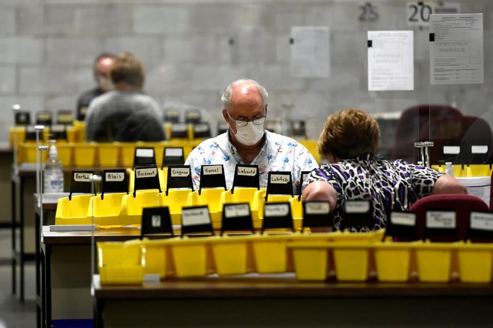 Workers prepare the bins with names of candidates into which special ballots from national, international, Canadian Forces and incarcerated electors will be counted and organized, at Elections Canada's distribution centre in Ottawa on election night of the 44th Canadian general election, on Monday, Sept. 20, 2021.