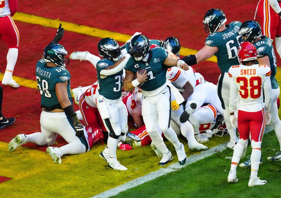 Philadelphia Eagles quarterback Jalen Hurts (1) celebrates scoring a touchdown on a quarterback sneak against the Kansas City Chiefs during the first quarter in Super Bowl LVII at State Farm Stadium.