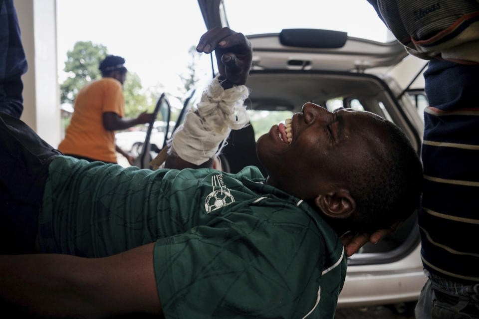 An injured man on a stretcher is loaded into a medical vehicle to be taken to hospital after being being beaten by soldiers in the Sizinda Township, Bulawayo, Zimbabwe Wednesday, Jan 16, 2019. Widespread reports of violence continued as Zimbabwe faced a third day of protests over what has become the world's most expensive gasoline. (AP Photo/KB Mpofu)