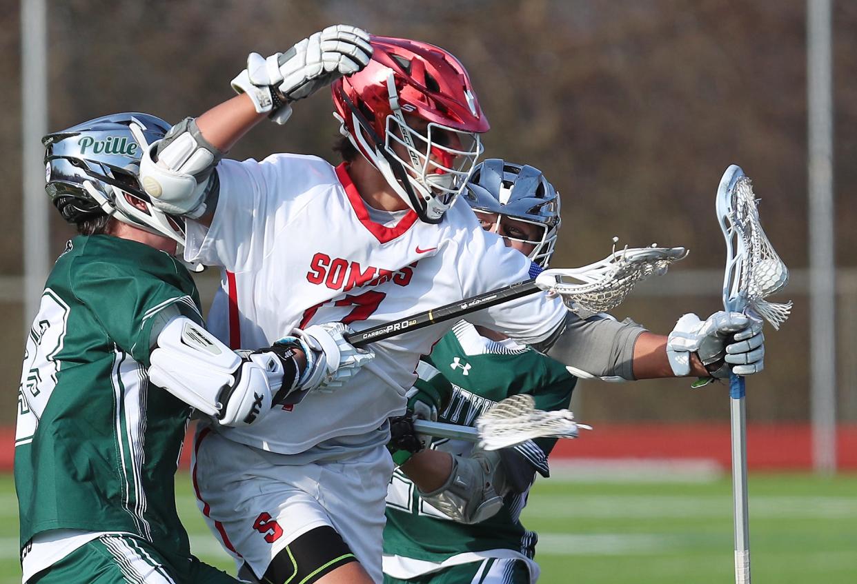 Somers' Miguel Iglesias (7) tries to get between Pleasantville's Hank McCourtney (33) and Emmett McDermott (22) during boys lacrosse action at  Somers High School April 4, 2023. Pleasantville won the game 13-5.