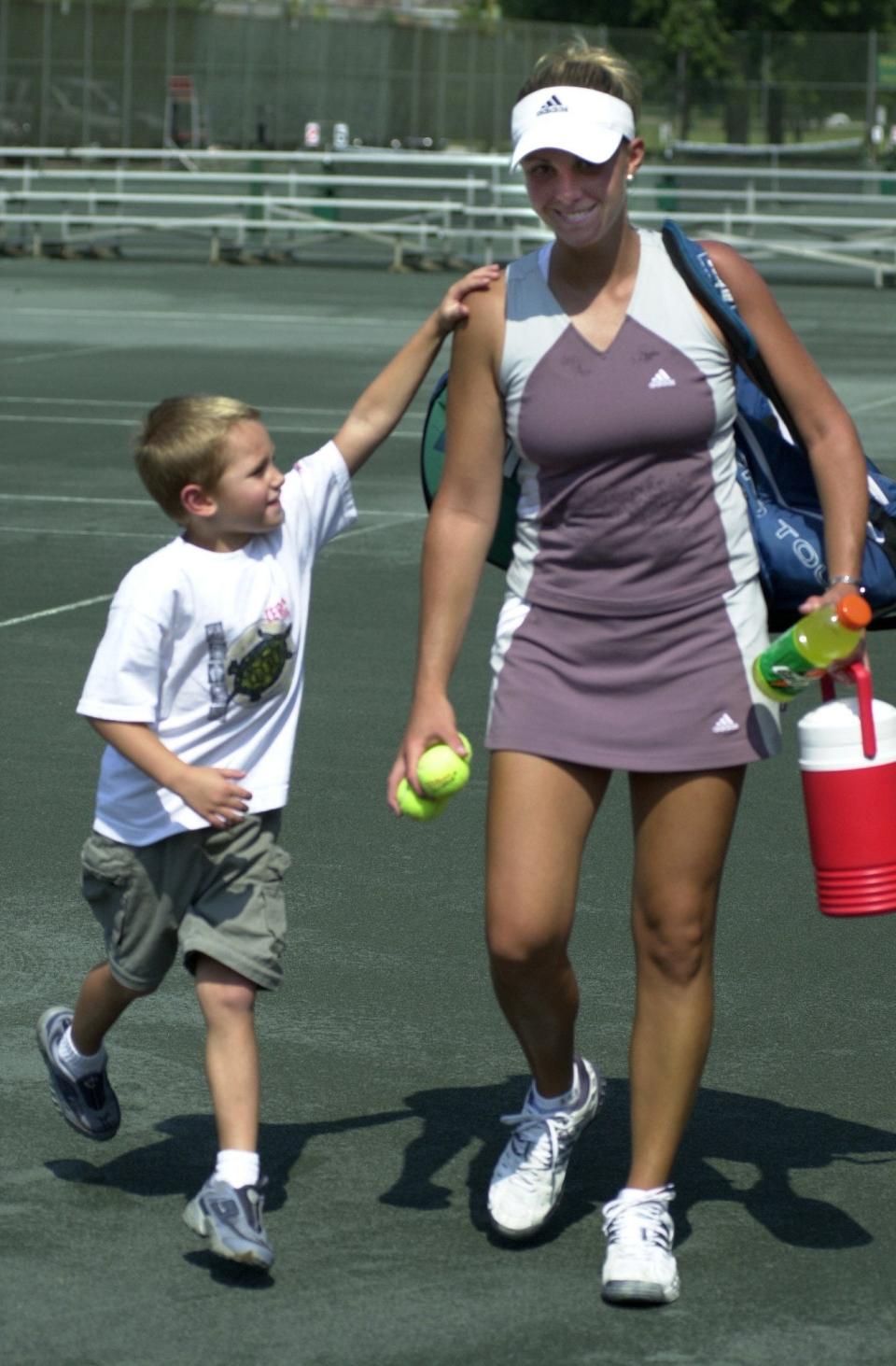 Kara Molony-Hussey leaves the court with her son Austin, 5 after winning her semi-finals 5-0 at the Thomas E. Price Cincinnati Metropolitan Tennis Tournament at the Lunken Play Field on July 20, 2002.