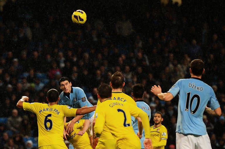 Manchester City's Gareth Barry (2nd L) climbs onto Reading's Nicky Shorey to score the winning goal during their Premier League match on December 22, 2012. City broke the deadlock when Barry headed home from a David Silva cross