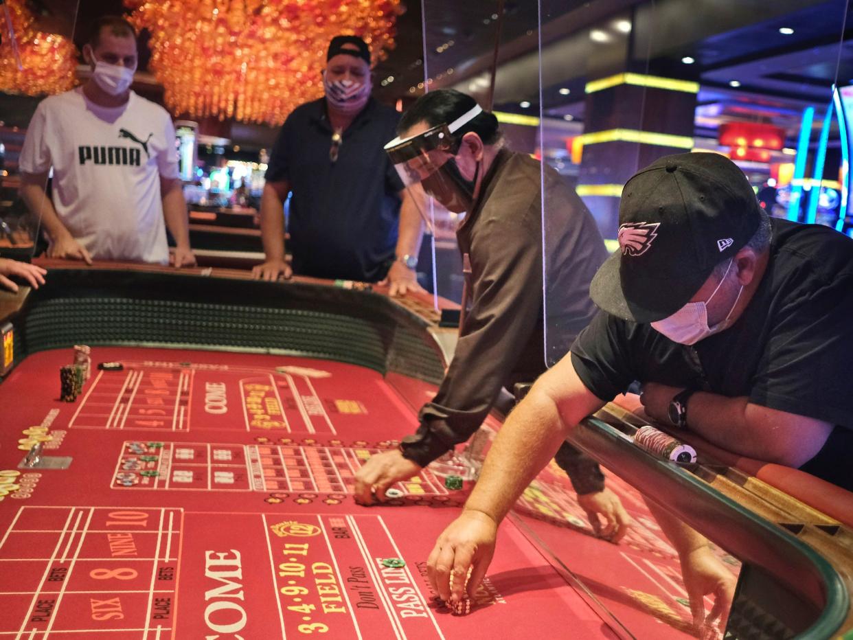 Craps players and dealers are seperated by partitions at the Golden Nugget Casino in Atlantic City, N.J., Thursday, July 2, 2020. Eager to hit the slot machines and table games after a 108-day absence, gamblers wore face masks and did without smoking and drinking Thursday as Atlantic City's casinos reopened amid the coronavirus pandemic that has drastically changed things both inside and outside the casino walls.