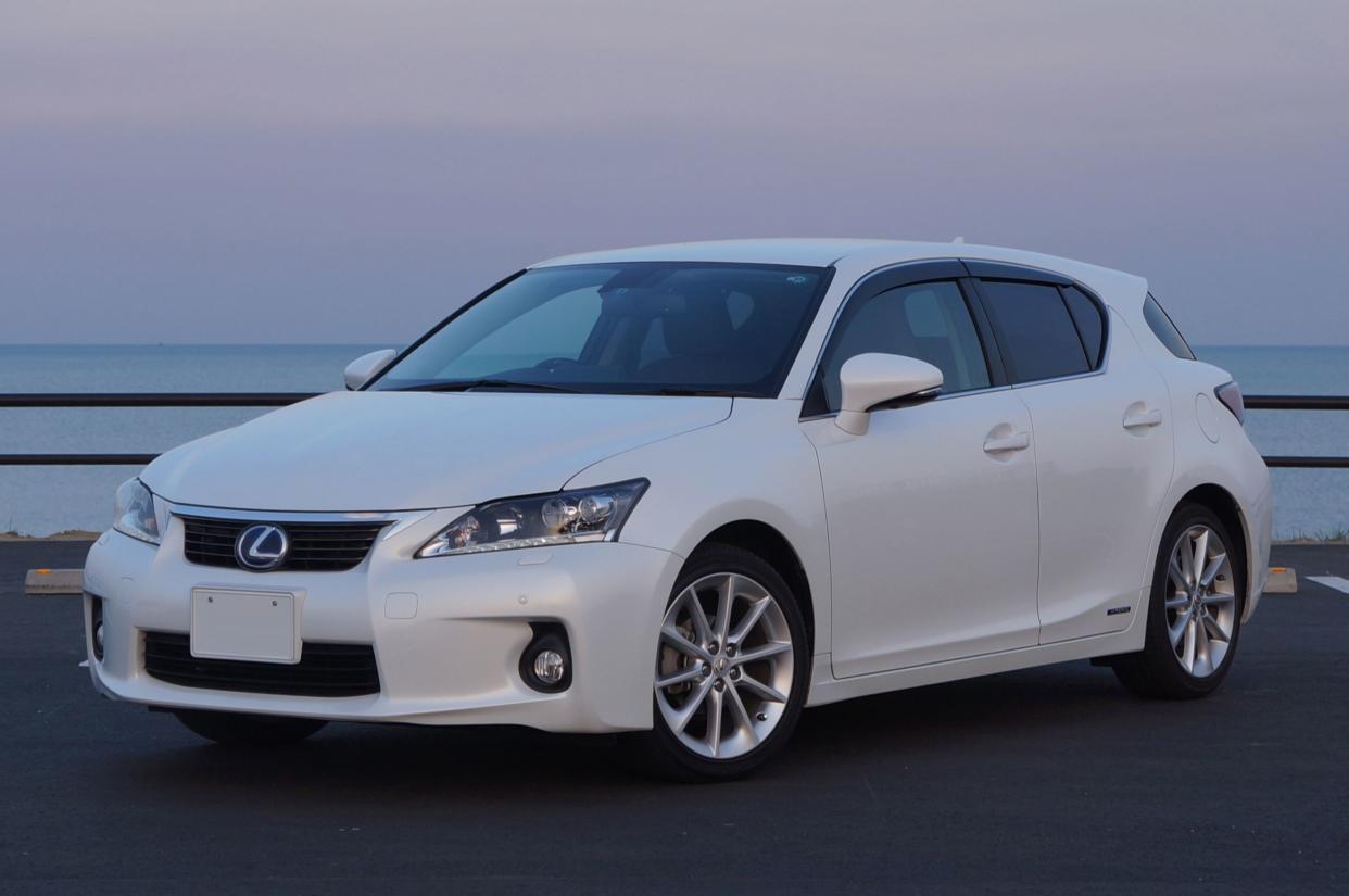 White 2011 Lexus CT200h parked by harbor at sunset.