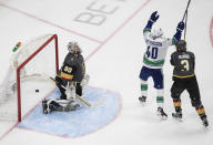 Vancouver Canucks' Elias Pettersson (40) celebrates a goal on Vegas Golden Knights goalie Robin Lehner (90), next to Brayden McNabb (3) during the third period of Game 5 of an NHL hockey second-round playoff series, Tuesday, Sept. 1, 2020, in Edmonton, Ontario. (Jason Franson/The Canadian Press via AP)