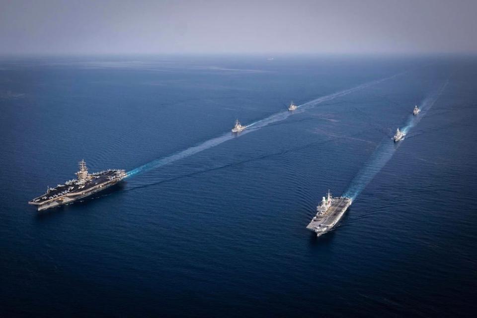 Two lines of warships belonging to the US Navy and Italian navy sail in formation