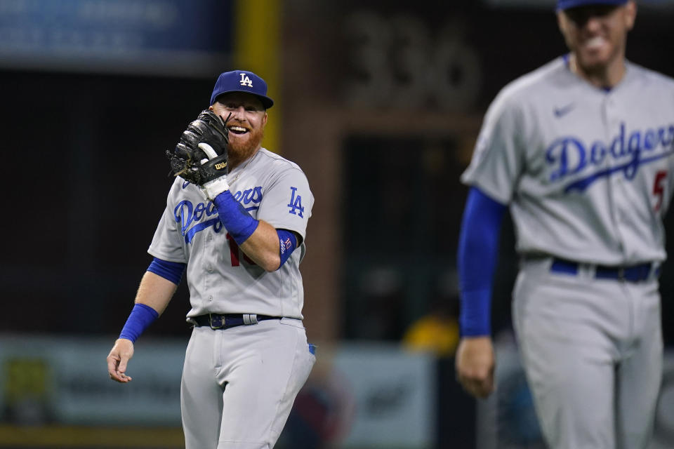 Los Angeles Dodgers third baseman Justin Turner, left, jokes with first baseman Freddie Freeman during the fifth inning of the team's baseball game against the San Diego Padres, Friday, Sept. 9, 2022, in San Diego. (AP Photo/Gregory Bull)