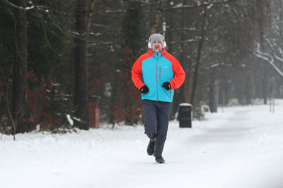 A man jogs down a snow covered street in Catterick, North YorkshirePA