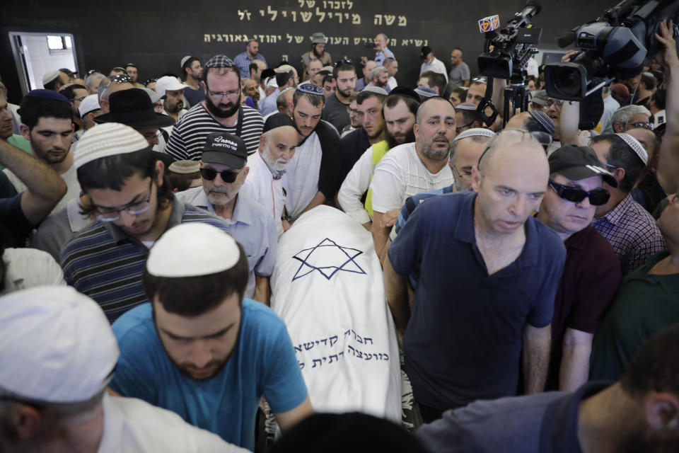 People attend the funeral of 17 year old Rina Shnerb, in Lod, Israel, Friday, Aug. 23, 2019. Shnerb has died of wounds from an explosion in the West Bank that the Israeli military has described as a Palestinian attack. (AP Photo/Sebastian Scheiner)