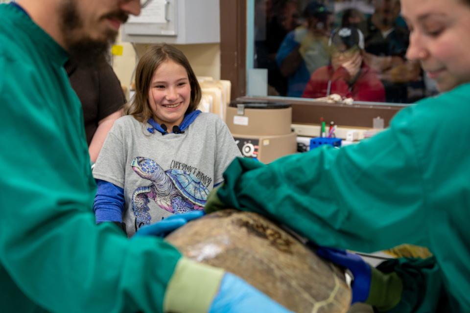 Kendall Barfield (center) meeting Bandit, a turtle who lives at the Georgia Sea Turtle Center on Jekyll Island. Bandit suffers from a similar condition to Barfield, who has spina bifida.