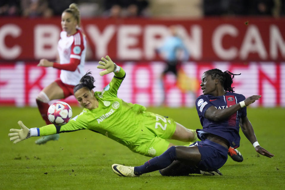 FILE - PSG's Tabitha Chawinga, right, scores her side's first goal past Bayern goalkeeper Maria-Luisa Grohs during the women's Champions League group C soccer match between FC Bayern Munich and Paris Saint-Germain in Munich, Germany, Tuesday, Jan. 30, 2024. Paris Saint-Germain forward Tabitha Chawinga faced challenges as a young soccer player growing up in Malawi. Her parents disapproved and wanted her to stop playing. (AP Photo/Matthias Schrader, File)